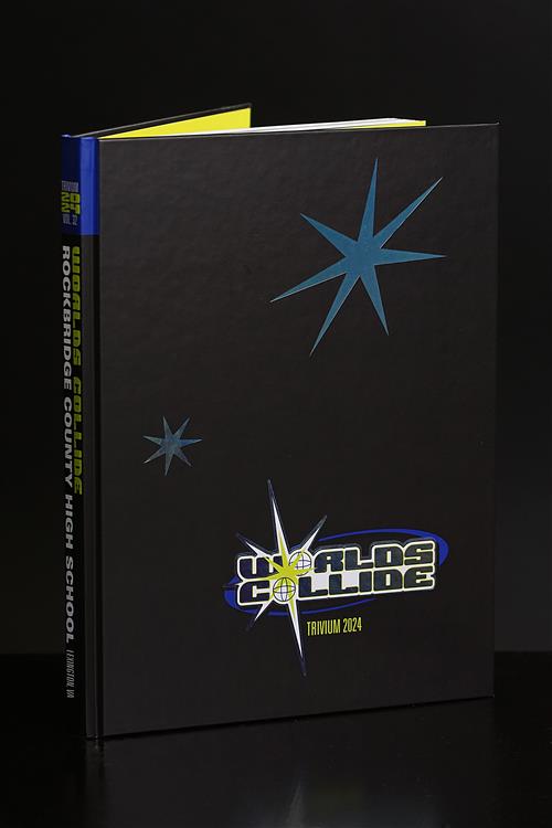 A black yearbook with the title "Worlds Collide" and the year "Trivium 2024" on the cover.